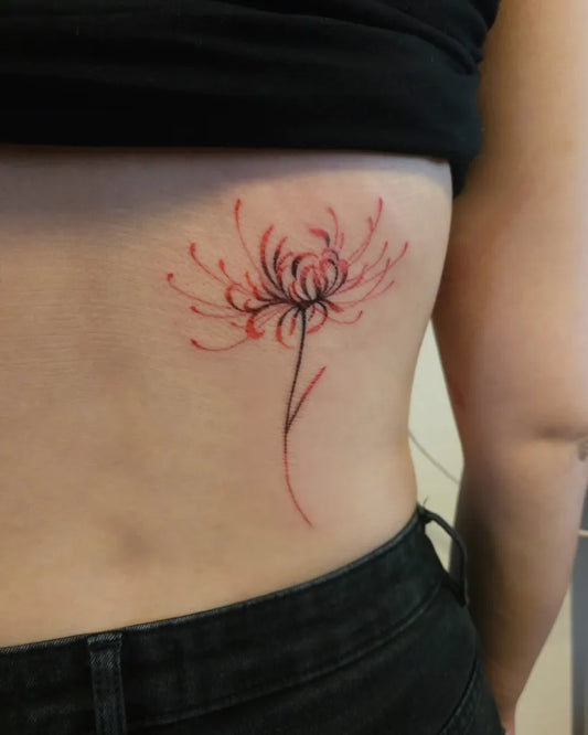 Small Fine Line Red Spider Lily Tattoo on Women Hip by @inna.faith.tattoo