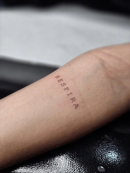 Small Fine Line Respirar Quote Tattoo on Women Forearm by @sailorstattoomilanoduomo