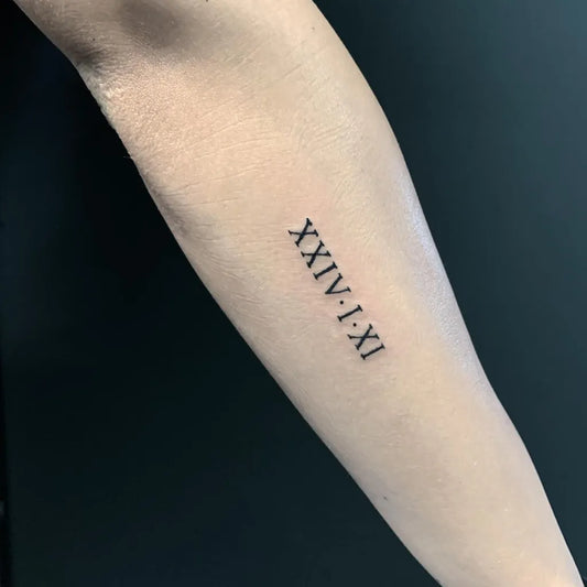Small Fine Line Roman Numerals Tattoo on Women Forearm by @blacksoul_tattoostudio