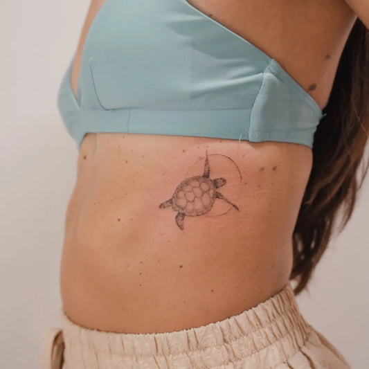 Small Fine Line Sea Turtle Tattoo on Women Rib by @blancart.studio