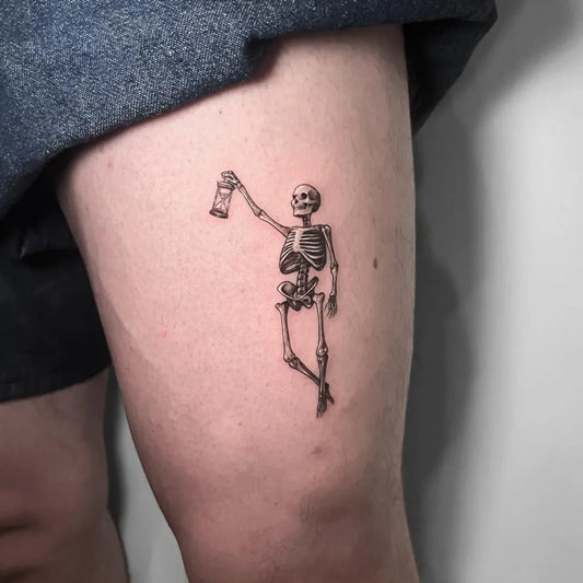 Small Fine Line Skeleton with Lantern Tattoo on Women Thigh by @artbus.tattoo