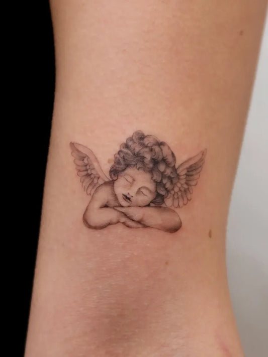 Small Fine Line Sleeping Angel on Women Arm Tattoo by @filll.ink
