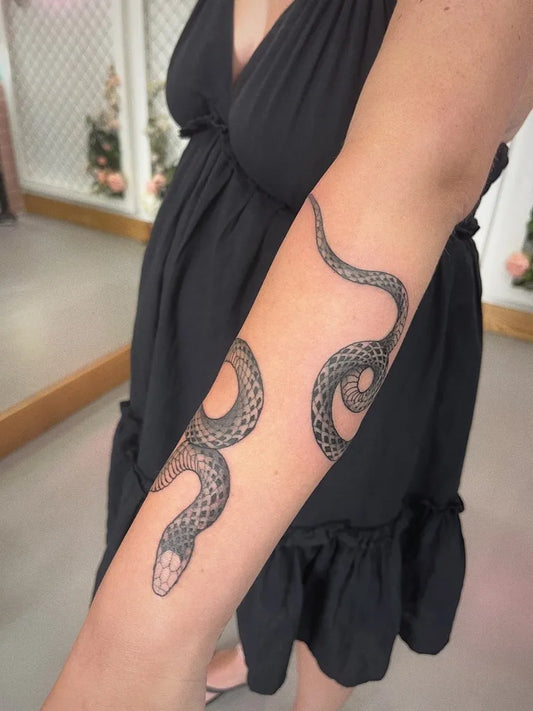 Small Fine Line Snake on Women Arm Tattoo by @lukeoakmantattoo