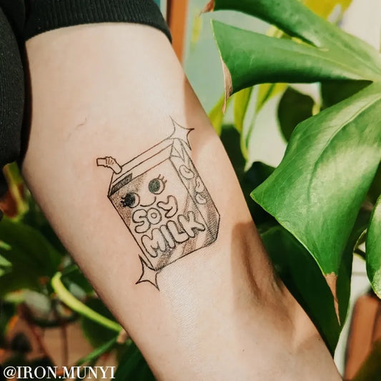 Small Fine Line Soy Milk Cartoon Tattoo on Women Inner Arm by @iron.munyi