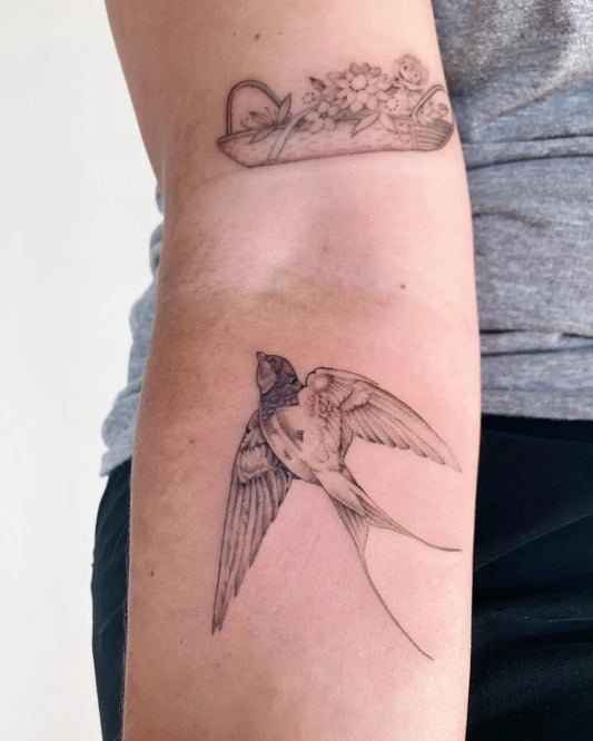 Small Fine Line Sparrow and Flowers Tattoo on Women Arm by @misslizzietattoo