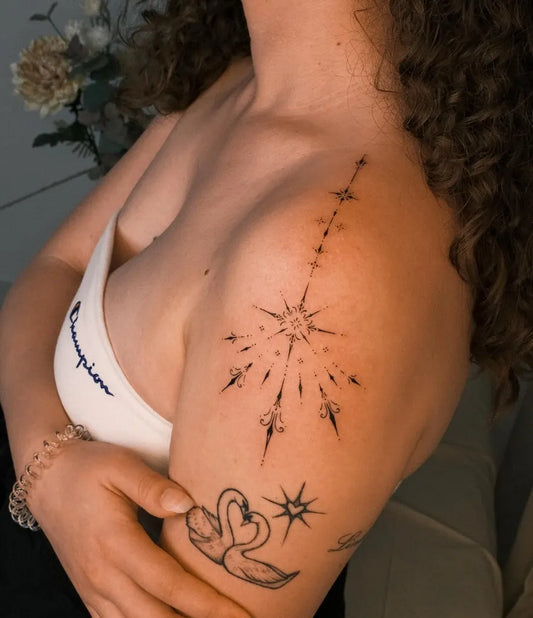 Small Fine Line Star with Rays Swans on Women Shoulder Tattoo by @senadala_