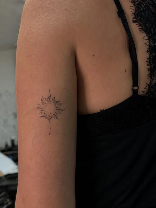 Small Fine Line Sun with Flames on Women Shoulder Tattoo by @qiongyu_art