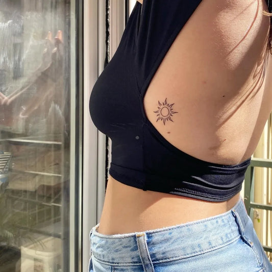 Small Fine Line Sun with Leaves on Women Side Tattoo by @magalunaris.tattoo