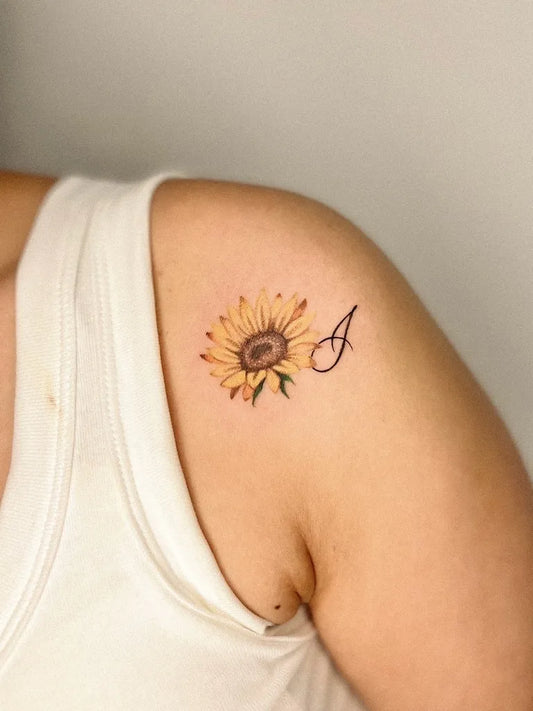 Small Fine Line Sunflower and Initial on Women Shoulder Tattoo by @tangkytattoo