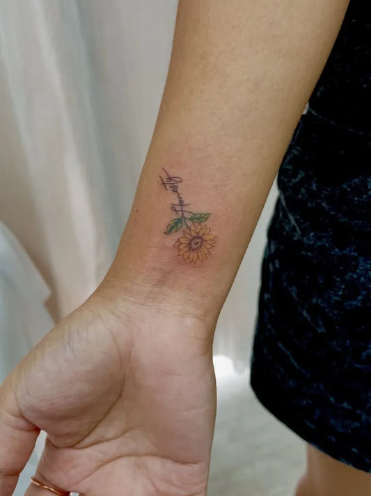 Small Fine Line Sunflower and Stem on Women Wrist Tattoo by @tattoo_thailand
