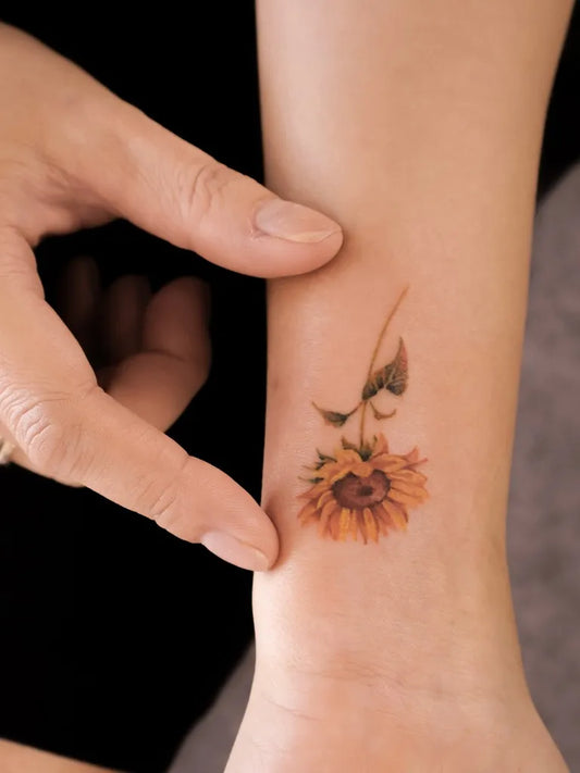 Small Fine Line Sunflower on Women Wrist Tattoo by @solin.tattoo
