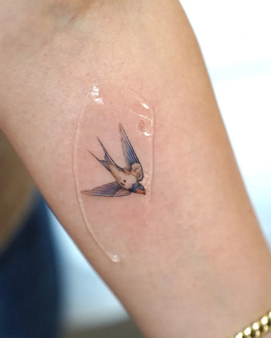 Small Fine Line Swallow Bird Tattoo on Women Arm by @tattooartbyhailey