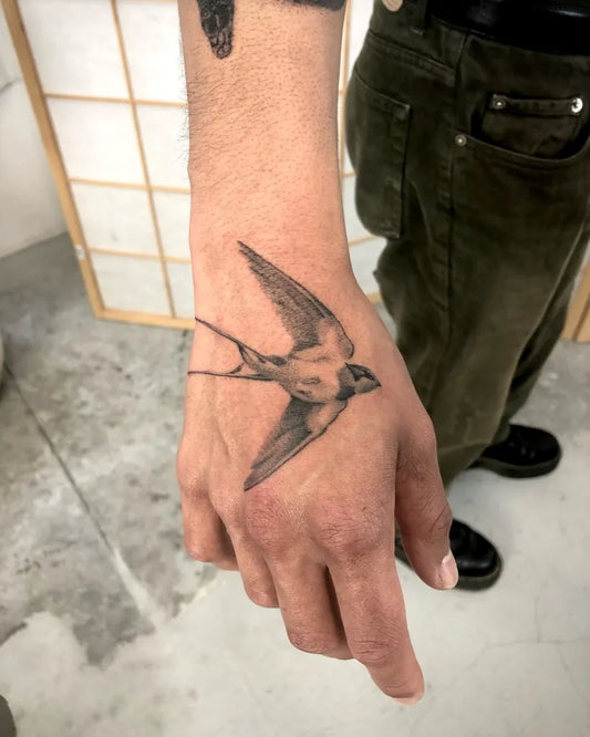 Small Fine Line Swallow Tattoo on Men Hand by @sztuka_wojny