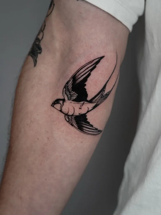 Small Fine Line Swallow Tattoo on Men Upper Arm by @saliibaj