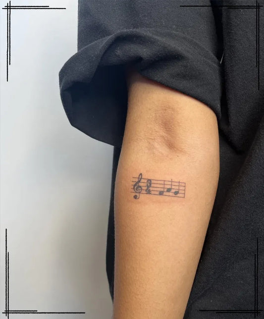 Small Fine Line Treble Clef and Staff Music Tattoo on Women Arm by @viiiicckk.tattoo