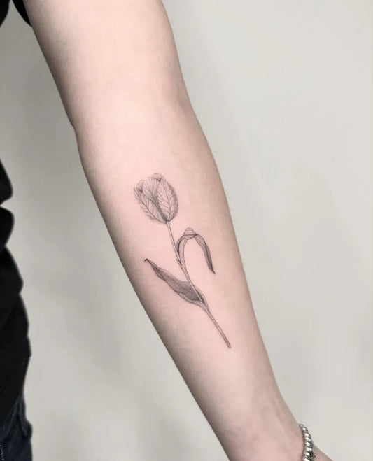 Small Fine Line Tulip Tattoo on Women Arm by @casa_bigotta