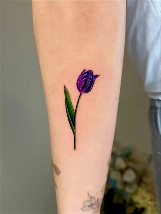 Small Fine Line Tulip Tattoo on Women Arm by @claire_tattoos_