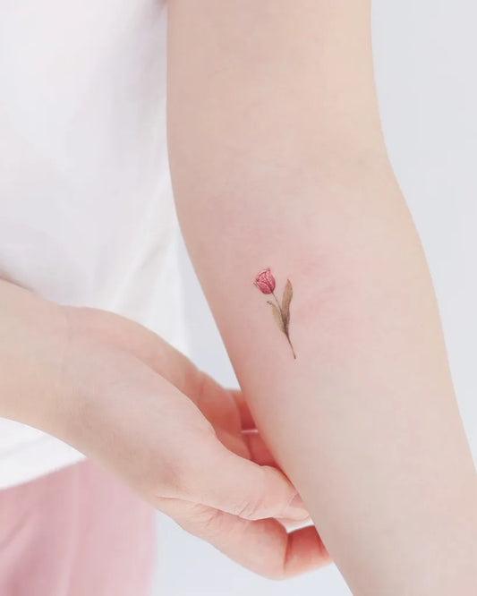 Small Fine Line Tulip Tattoo on Women Arm by @matt_tattooist