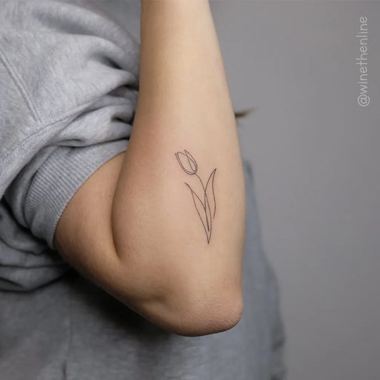 Small Fine Line Tulip Tattoo on Women Arm by @ohtheink
