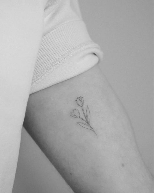 Small Fine Line Tulip Tattoo on Women Arm by @pelininaydin