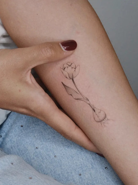 Small Fine Line Tulip Tattoo on Women Arm by @thewhiterabbit.studiotattoo