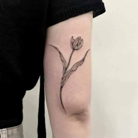 Small Fine Line Tulip Tattoo on Women Arm by @why.rose_tatart