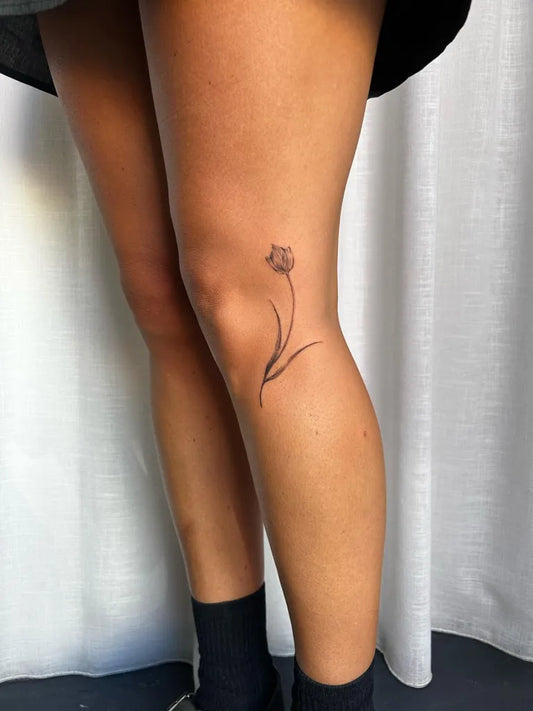 Small Fine Line Tulip Tattoo on Women Knee by @liliink_
