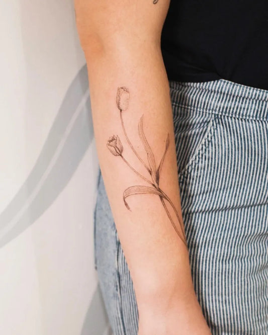Small Fine Line Tulip and Stems Tattoo on Women Arm by @le.nid.atelier