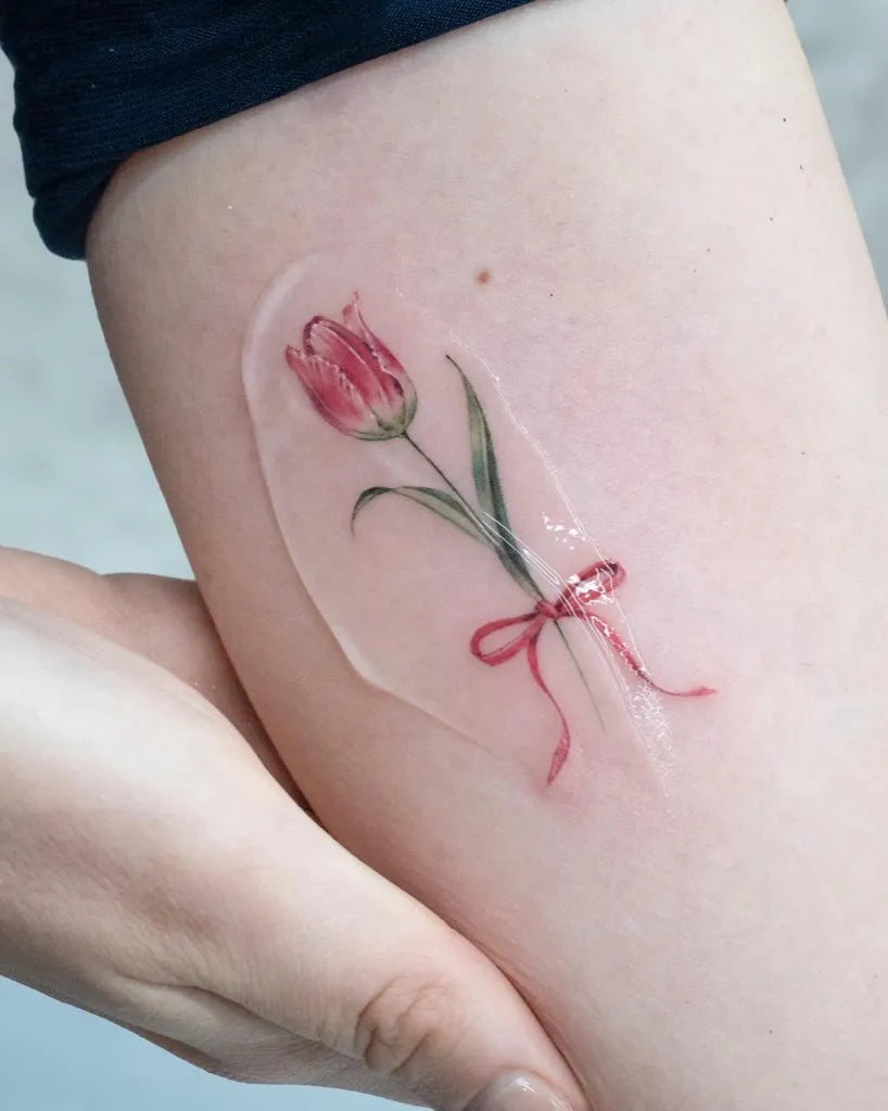 Small Fine Line Tulip with Bow Tattoo on Women Arm by @e.hye_tattoo