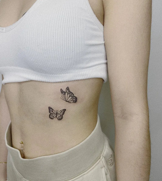 Small Fine Line Two Butterflies Tattoo on Women Rib by @mudi.ink