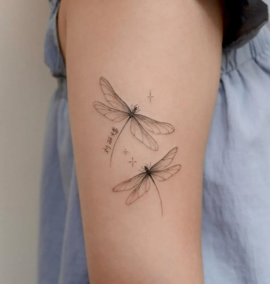 Small Fine Line Two Dragonflies with Stars on Women Arm Tattoo by @cels.tattoo