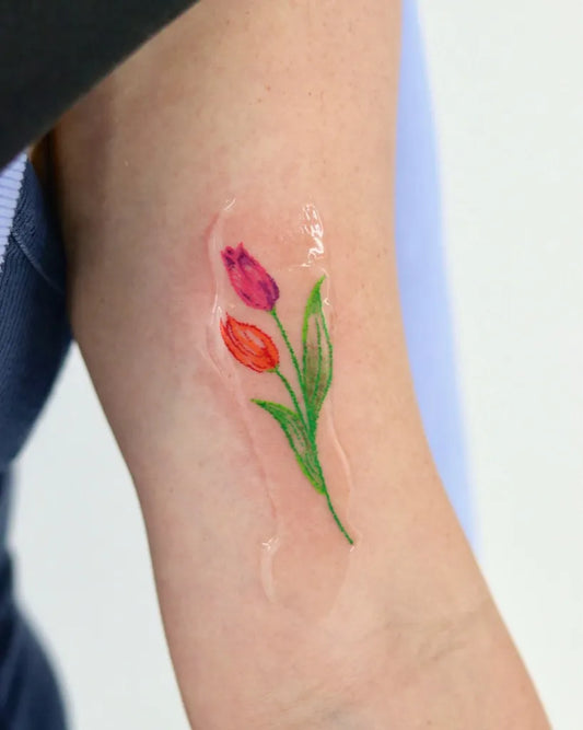 Small Fine Line Two Tulips Tattoo on Women Arm by @tina_colortattooist