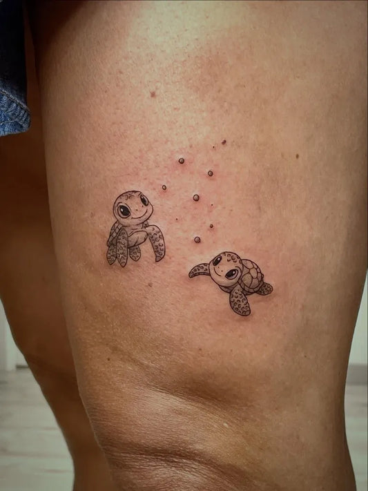 Small Fine Line Two Turtles Tattoo on Women Thigh by @naifstudiotattoo