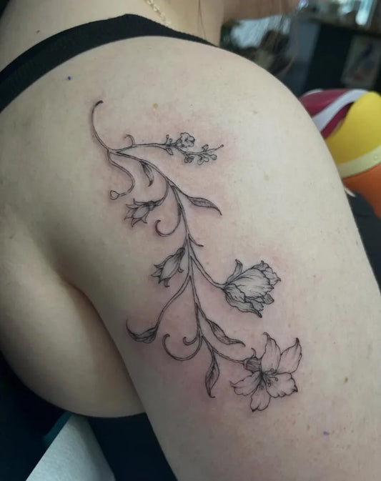 Small Fine Line Vine Lily Flowers on Women Shoulder Flower Tattoo by @flow_tattoo_toronto