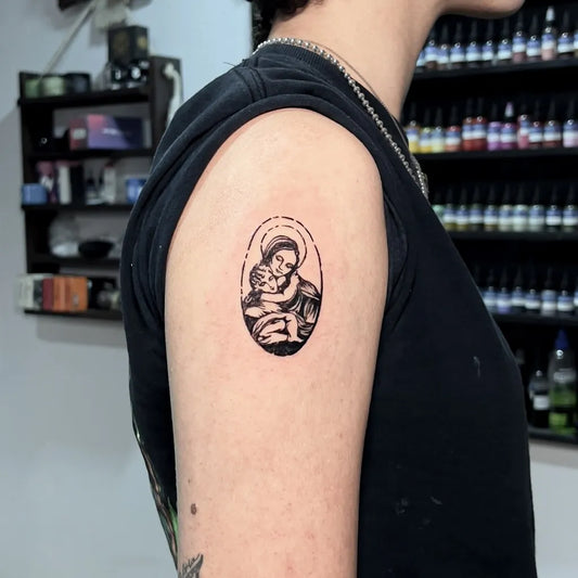 Small Fine Line Virgin Mary and Child Tattoo on Women Upper Arm by @chillhousetattoo