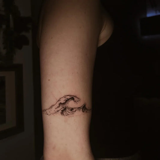 Small Fine Line Wave Tattoo on Women Arm by @averyscanvas