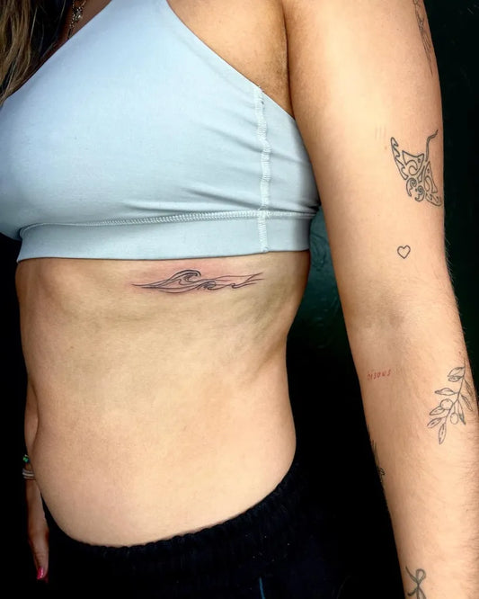 Small Fine Line Wave Tattoo on Women Rib by @ajltattoos