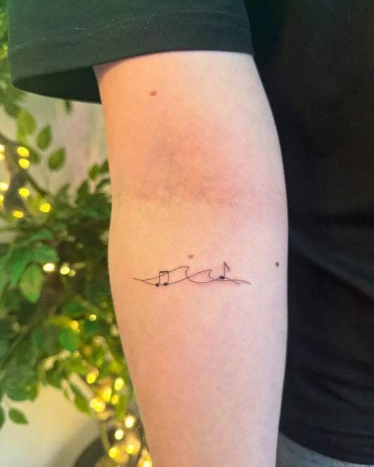 Small Fine Line Waves and Notes Music Tattoo on Women Arm by @aaronjtattoo