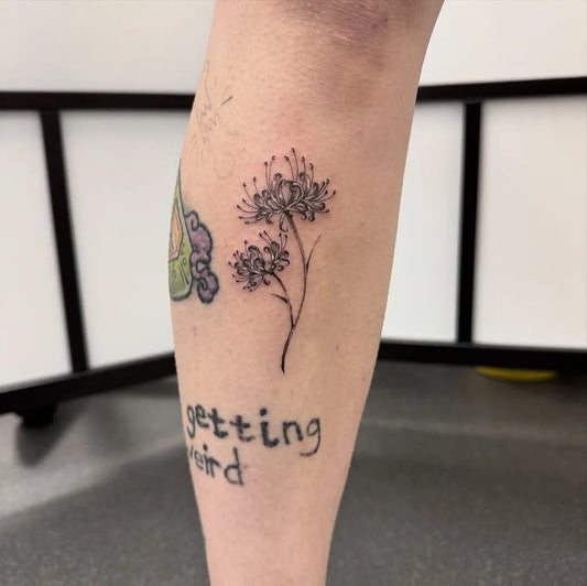 Small Fine Line White Spider Lily and Text Tattoo on Women Leg by @stxphy__art