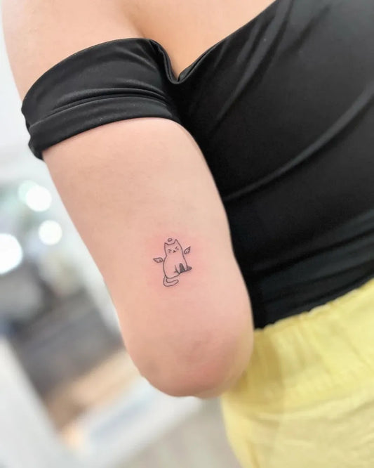 Small Fine Line Winged Cat on Women Arm Tattoo by @finelinetattoo.seminyak