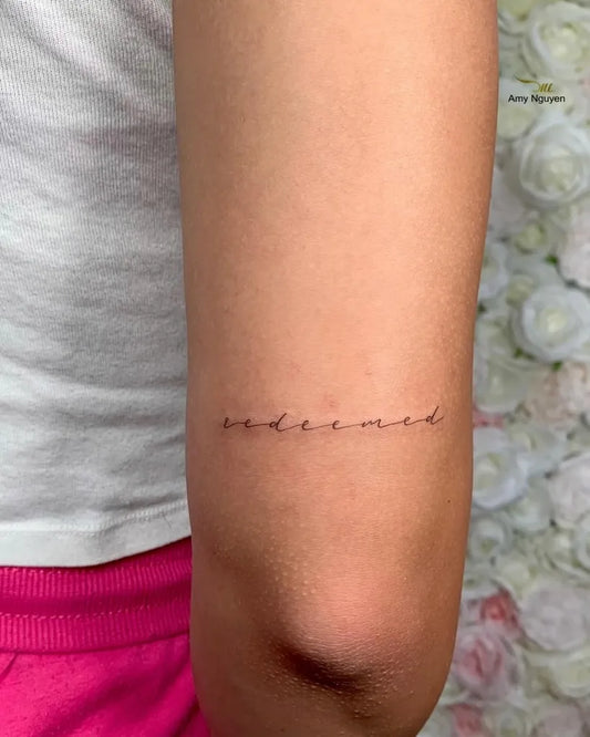 Small Fine Line Word on Women Upper Arm Tattoo by @amy.mailashaesthetics