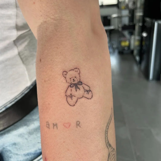 Small FineLine Bear with initials on Women Arm Tattoo by @bartekart