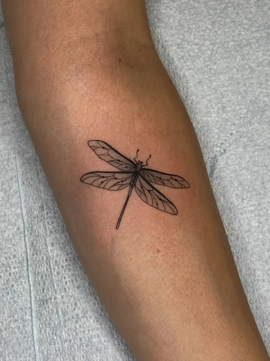 Small FineLine Dragonfly on Women Arm Tattoo by @peur_bleue.tattoo
