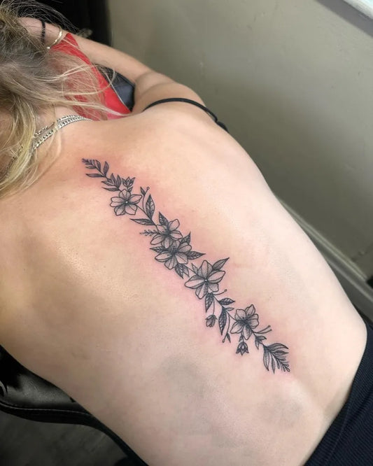 Small FineLine FloralVine on Women Spine Tattoo by @socks.tattoos