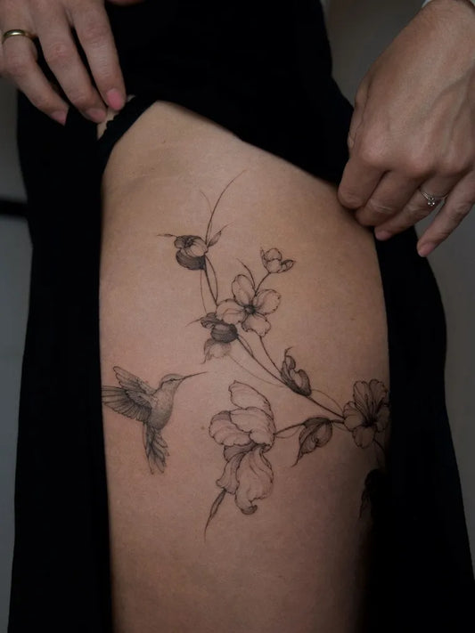 Small FineLine Hummingbird and Flowers on Women Thigh Tattoo by @kathrin.ink