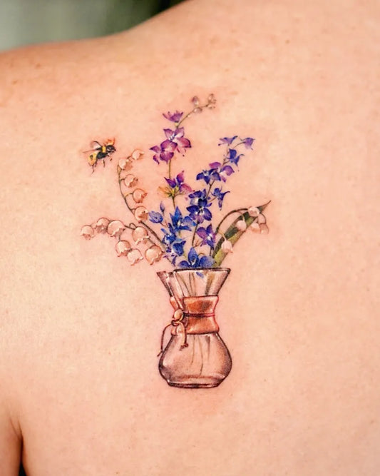 Small FineLine Lily of the Valley Vase with Flowers on Women Back Tattoo by @abii_tattoo