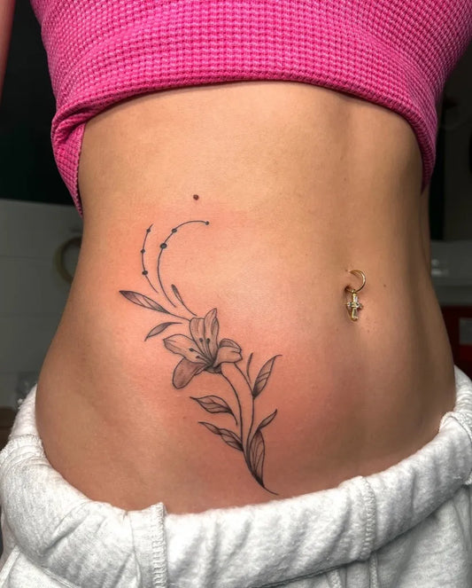 Small FineLine LilyBranch on Women Waist Tattoo by @cfaces.art