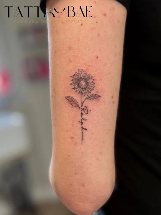 Small FineLine Sunflower and Name on Women Arm Tattoo by @tattoobaemcr