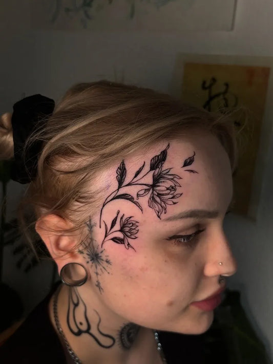 Small Floral Blackwork Flower Vine on Women Face Tattoo by @yaos.tattoo