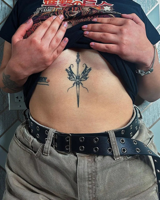 Small Gothic Dagger and Wings on Women Sternum Tattoo by @_j.inkx
